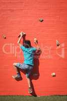 Boy climbing orange wall