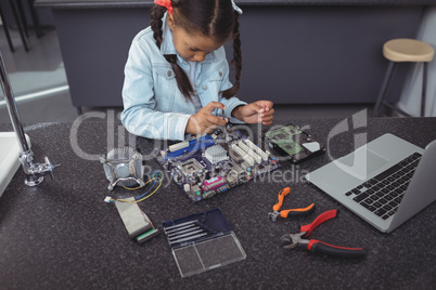 High angle view of concentrated elementary girl assembling circuit board