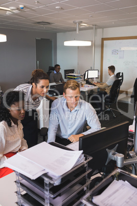Business colleagues looking at desktop monitor in office