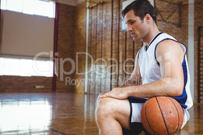SIde view of thoughtful basketball player