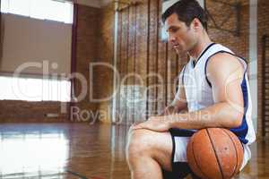 SIde view of thoughtful basketball player