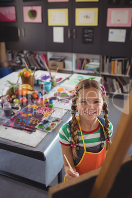 High angle portrait of girl painting on canvas