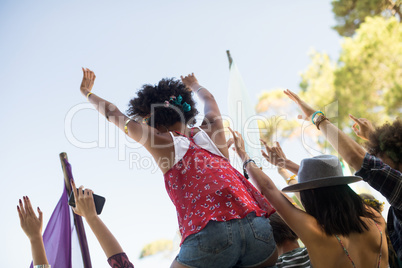 Tilt image of friends enjoying against sky at music festival