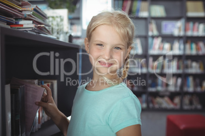 Portrait of girl choosing book from shelf