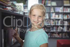 Portrait of girl choosing book from shelf