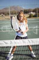 Portrait of girl playing tennis on court