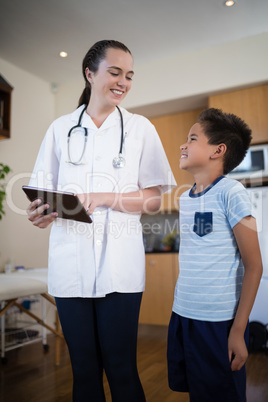 Smiling boy and female therapist with digital tablet