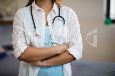 Midsection of female therapist standing with arms crossed