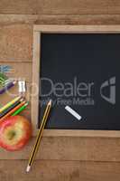 School supplies and apple on wooden table