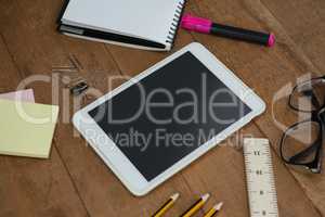 School supplies, digital tablet and spectacles on wooden table