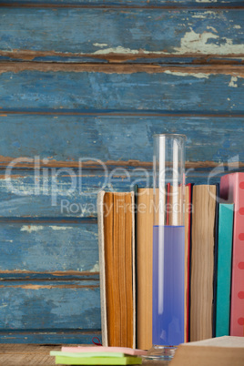 Stack of books, chemical test tube and sticky notes