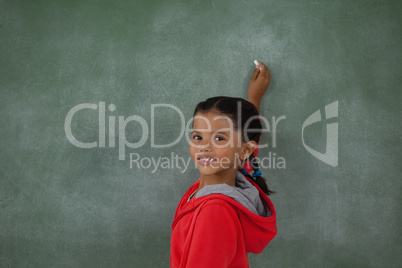 Young girl writing on chalk board