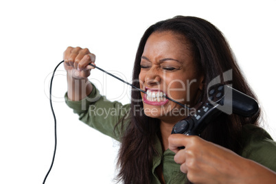 Frustrated woman biting a wire of joystick