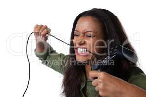 Frustrated woman biting a wire of joystick