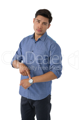 Portrait of young businessman showing time