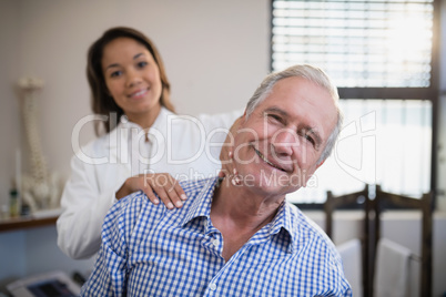 Portrait of smiling female therapist massaging neck