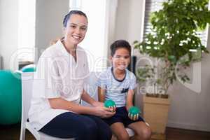 Portrait of smiling female therapist and boy holding stress balls