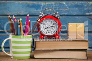 School supplies, alarm clock and wooden blocks on table