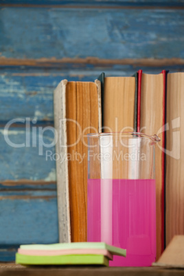 Stack of books, chemical beaker and sticky notes