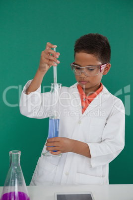 Attentive schoolboy doing a chemical experiment in laboratory