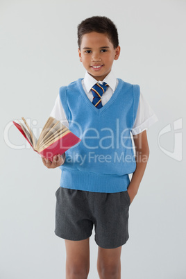 Schoolboy standing in front of chalkboard in classroom