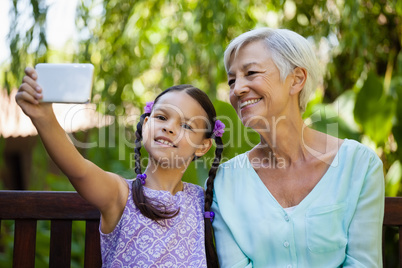 Smiling girl and grandmother taking selfie