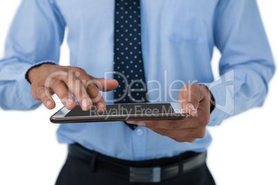 Mid section of businessman touching tablet computer