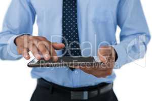 Mid section of businessman touching tablet computer