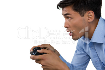 Side view of young businessman making face while playing video game