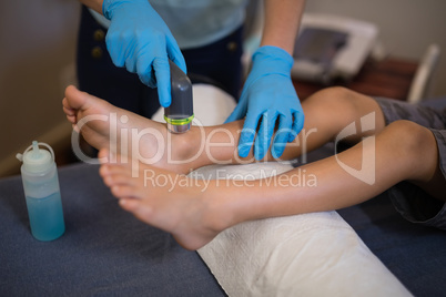 High angle view of female therapist scanning feet