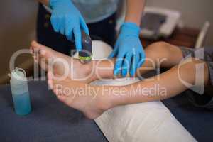 High angle view of female therapist scanning feet