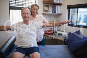 Smiling female doctor and male patient with arms outstretched