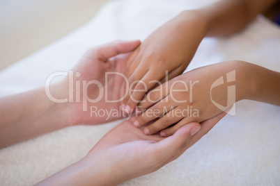 High angle view of female therapist examining hands on white towel