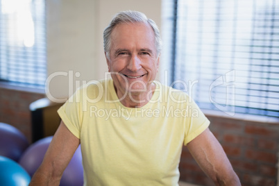 Portrait of smiling senior male patient against window