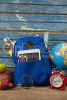 School supplies, apple, globe, digital tablet and magnifying glass on wooden table