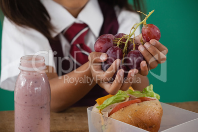 Schoolgirl having grape fruit
