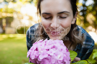 Close-up of woman with eyes closed smelling purple hydrangea flowers