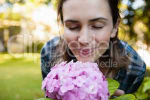 Close-up of woman with eyes closed smelling purple hydrangea flowers