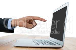 Cropped hand of businessman pointing on laptop