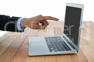 Cropped image of businessman pointing on laptop