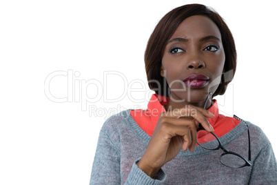 Thoughtful woman looking away while holding eyeglasses