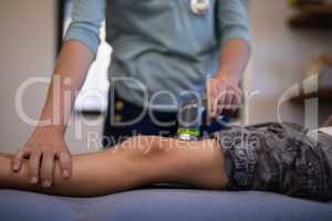Midsection of boy receiving ultrasound scan from female therapist