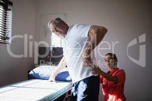 Senior man receiving back massage from female therapist