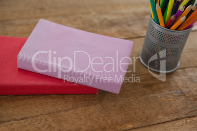 Books and color pencils on wooden table