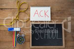 School supplies, alarm clock and measuring tape on wooden table