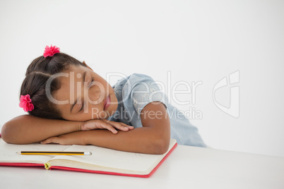 Young girl sleeping with her head on desk