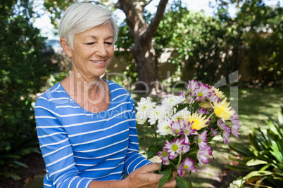 Smiling senior woman holding fresh flower bouquet