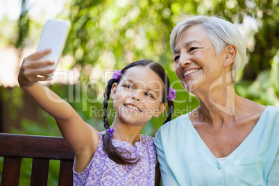 Smiling girl taking selfie with grandmother