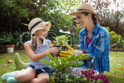 Smiling daughter and mother with potted plants