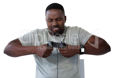 Frustrated man holding joystick against white background